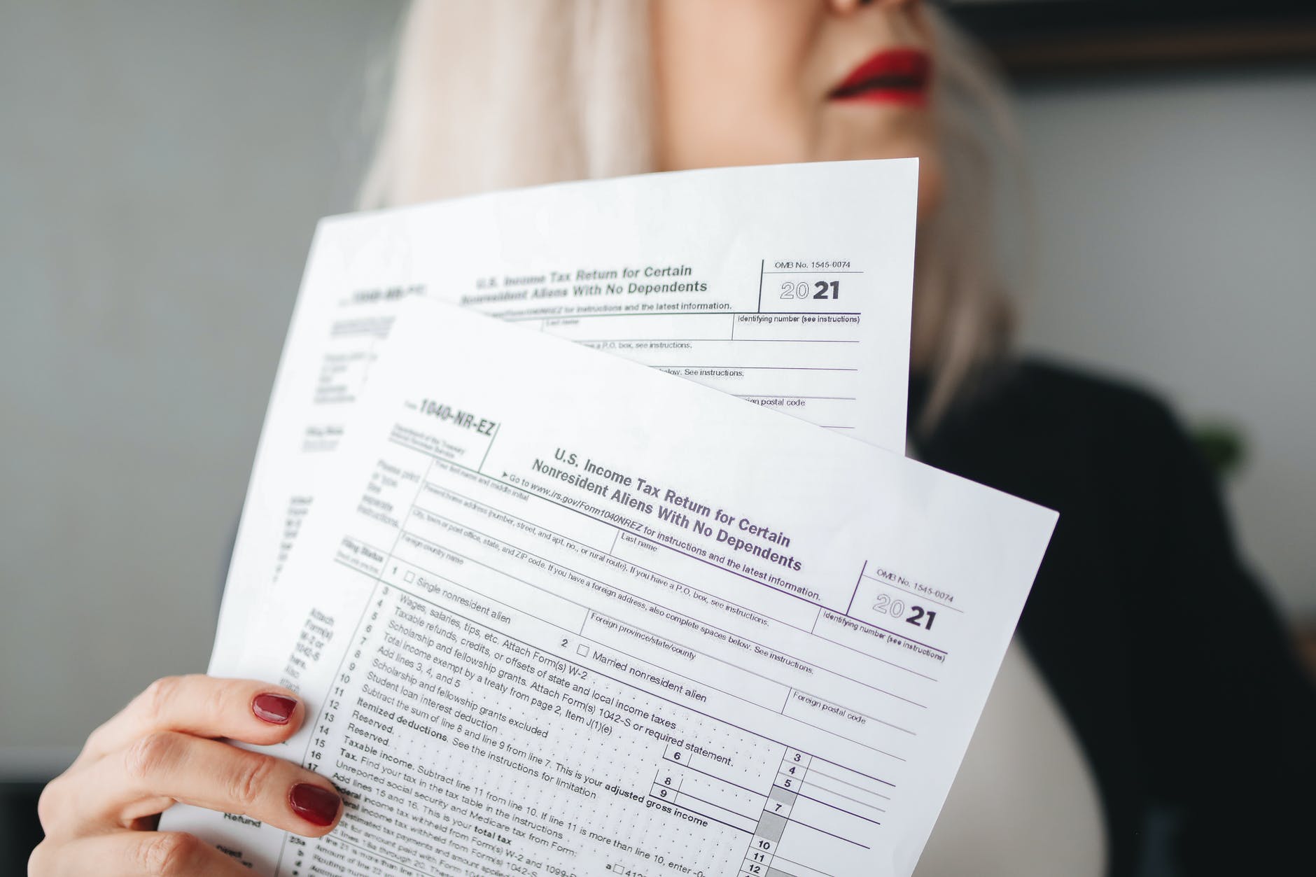 a woman holding white printer paper