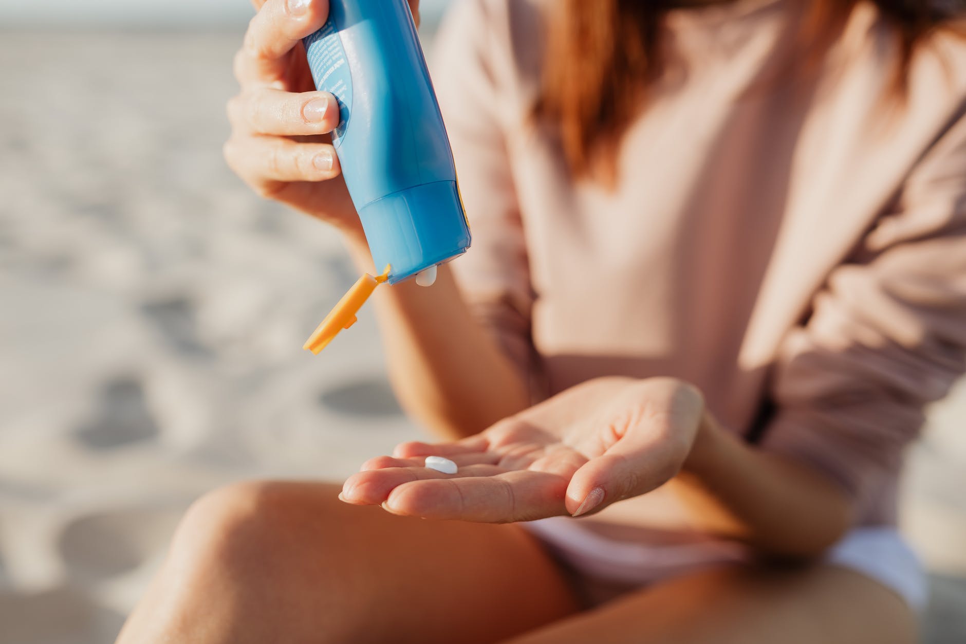 woman putting sunblock on her hand during summer