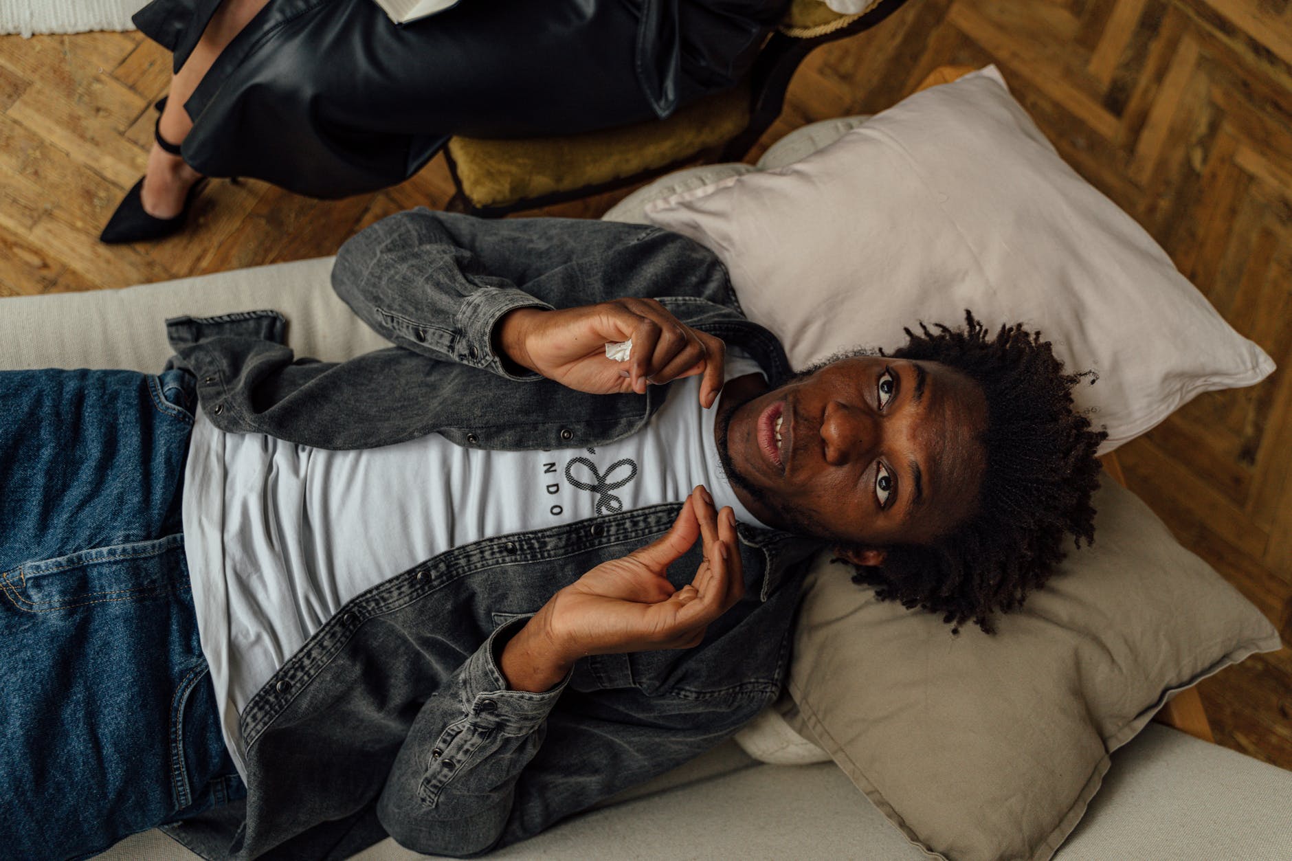 man in gray long sleeve shirt lying on bed managing your anxiety