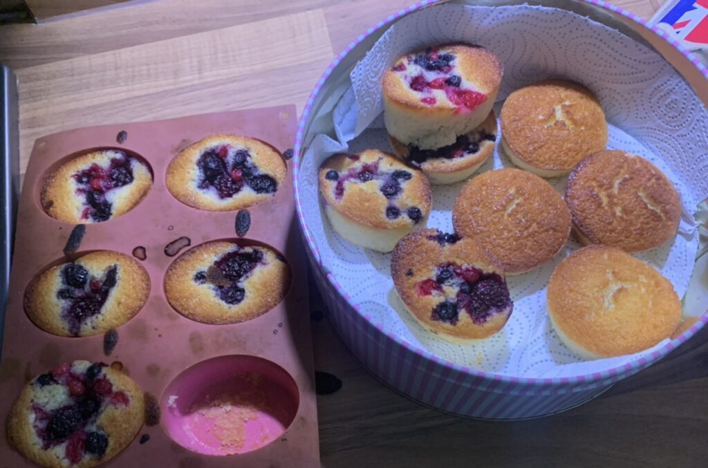 Friands in a pink baking tray and striped tin