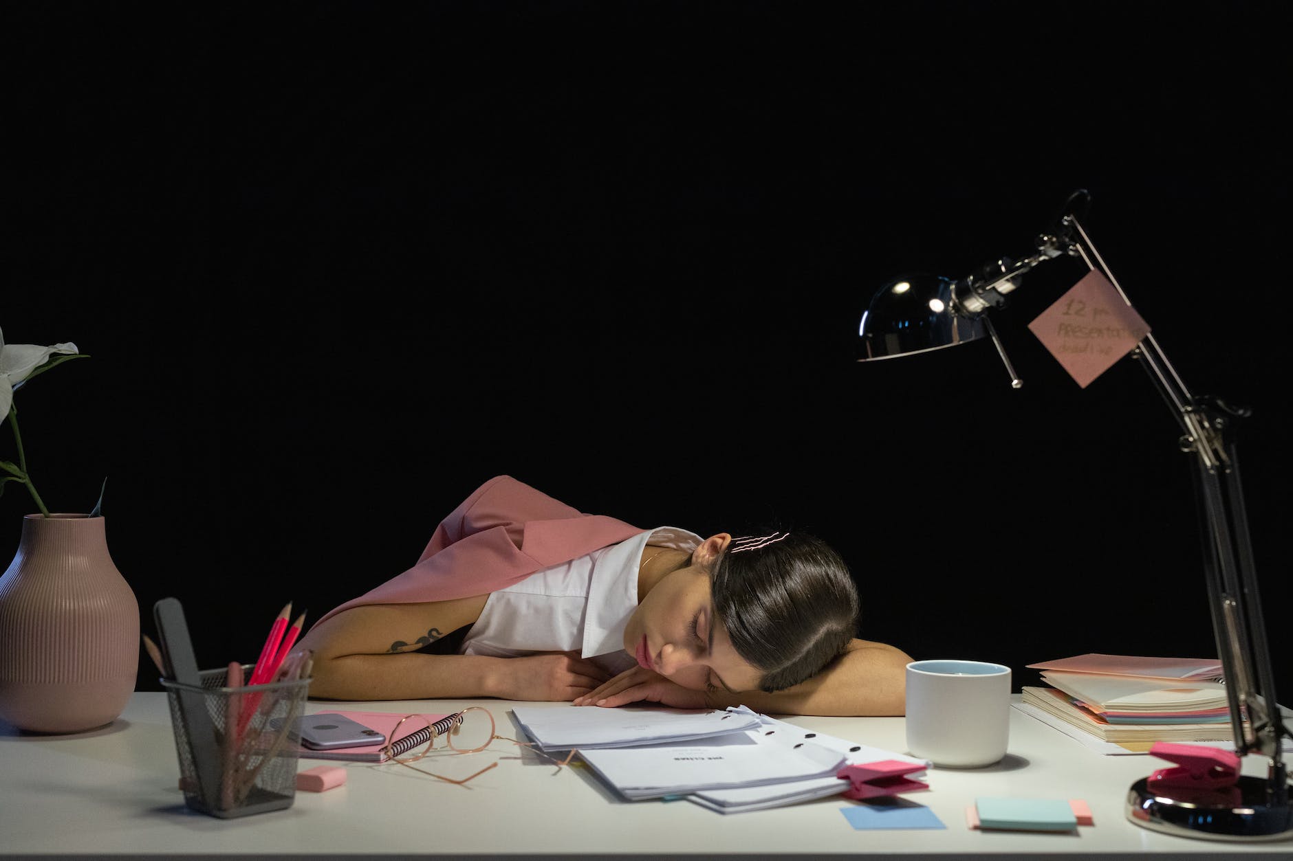 woman sleeping on desk unpaid overtime is killing us