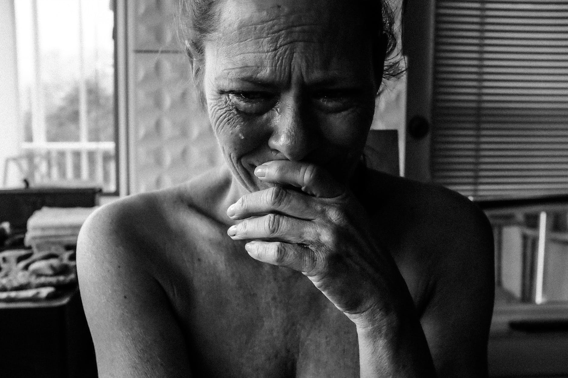 close up photography of crying woman next inside room