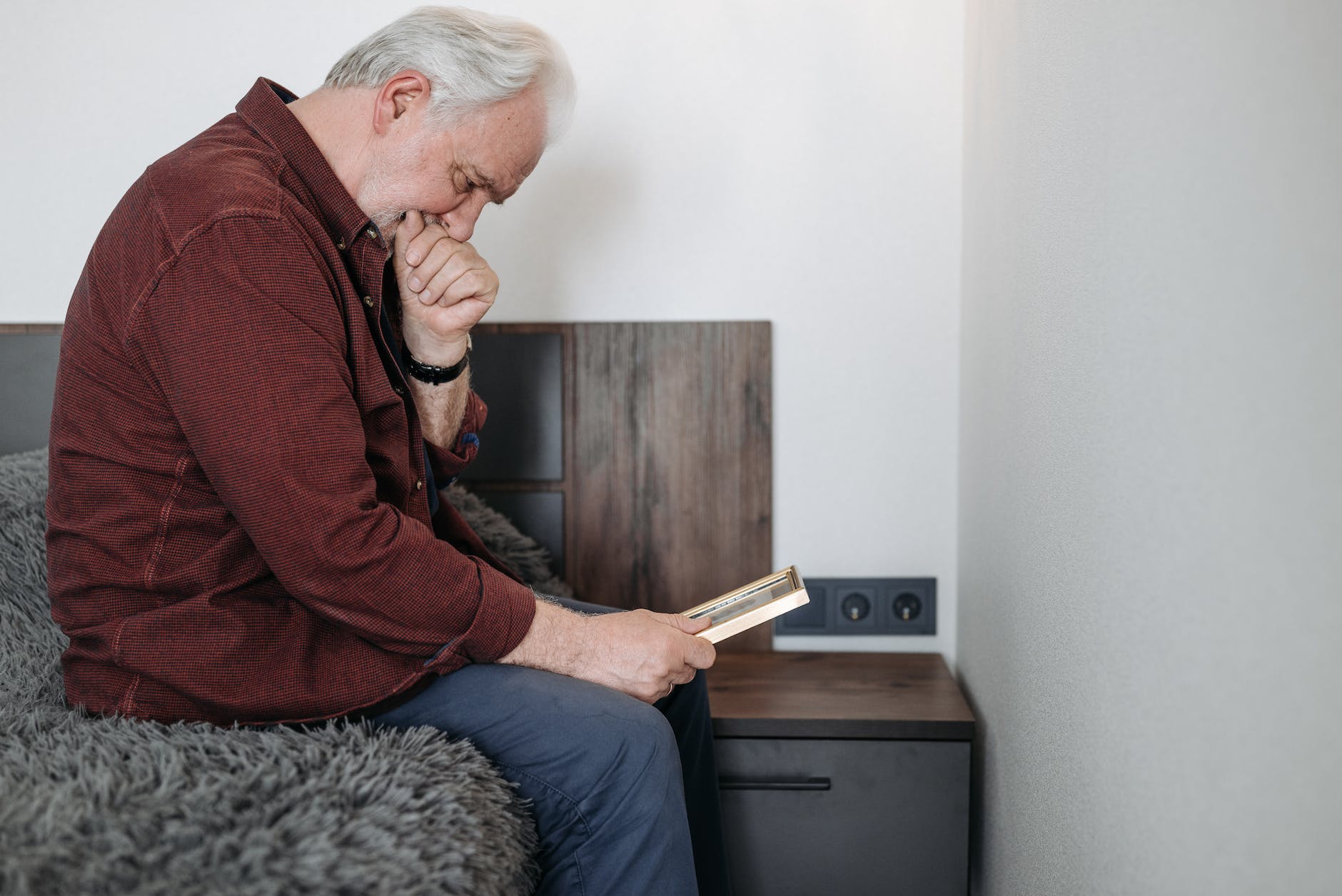 a man crying while holding a picture frame grief and loss