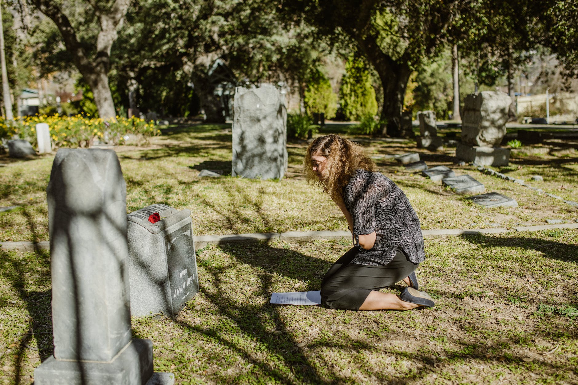 a woman grieving at a cemetery how to process grief
