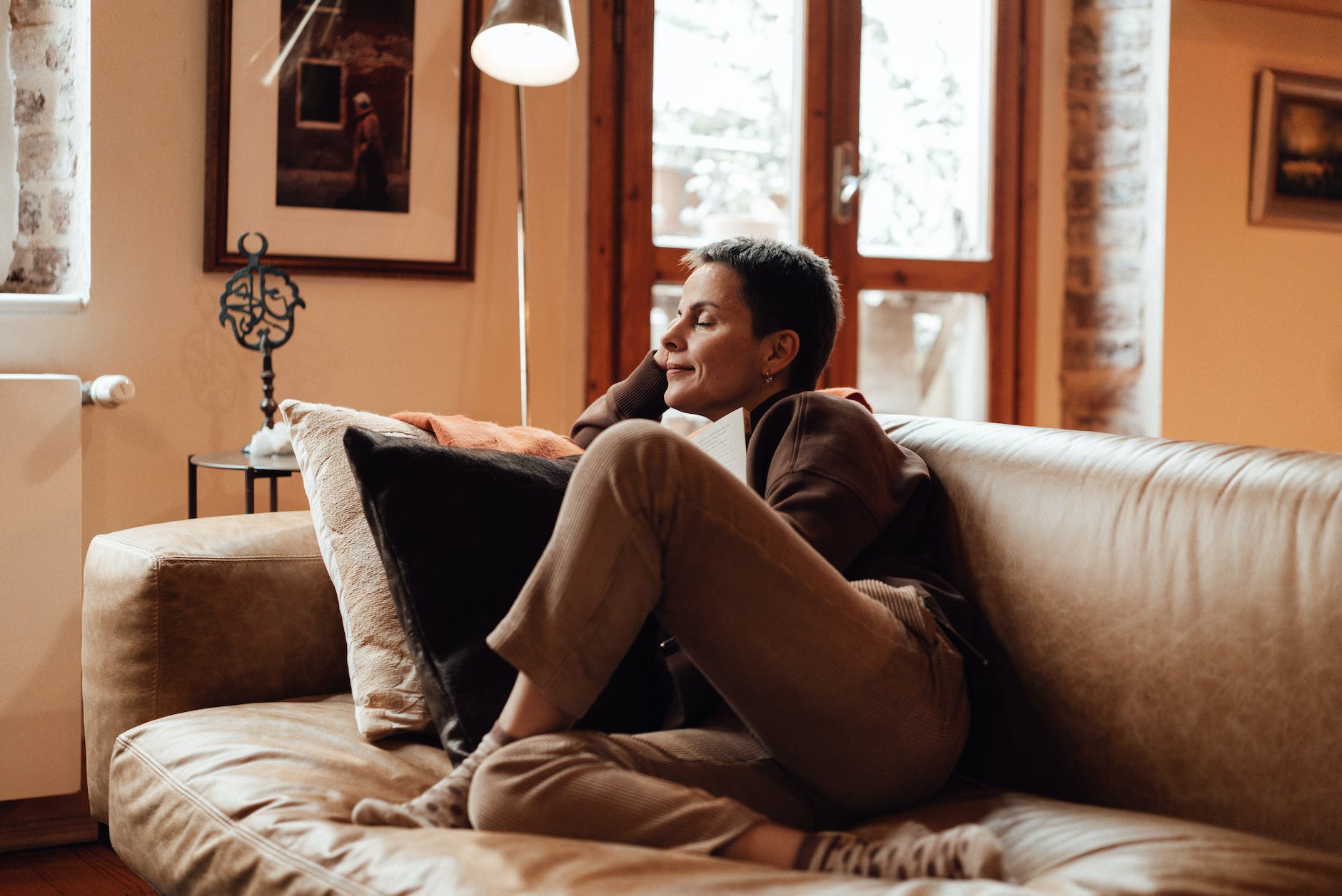 short haired woman sitting on couch. Having a haven is one of the ways to fight dysthymia